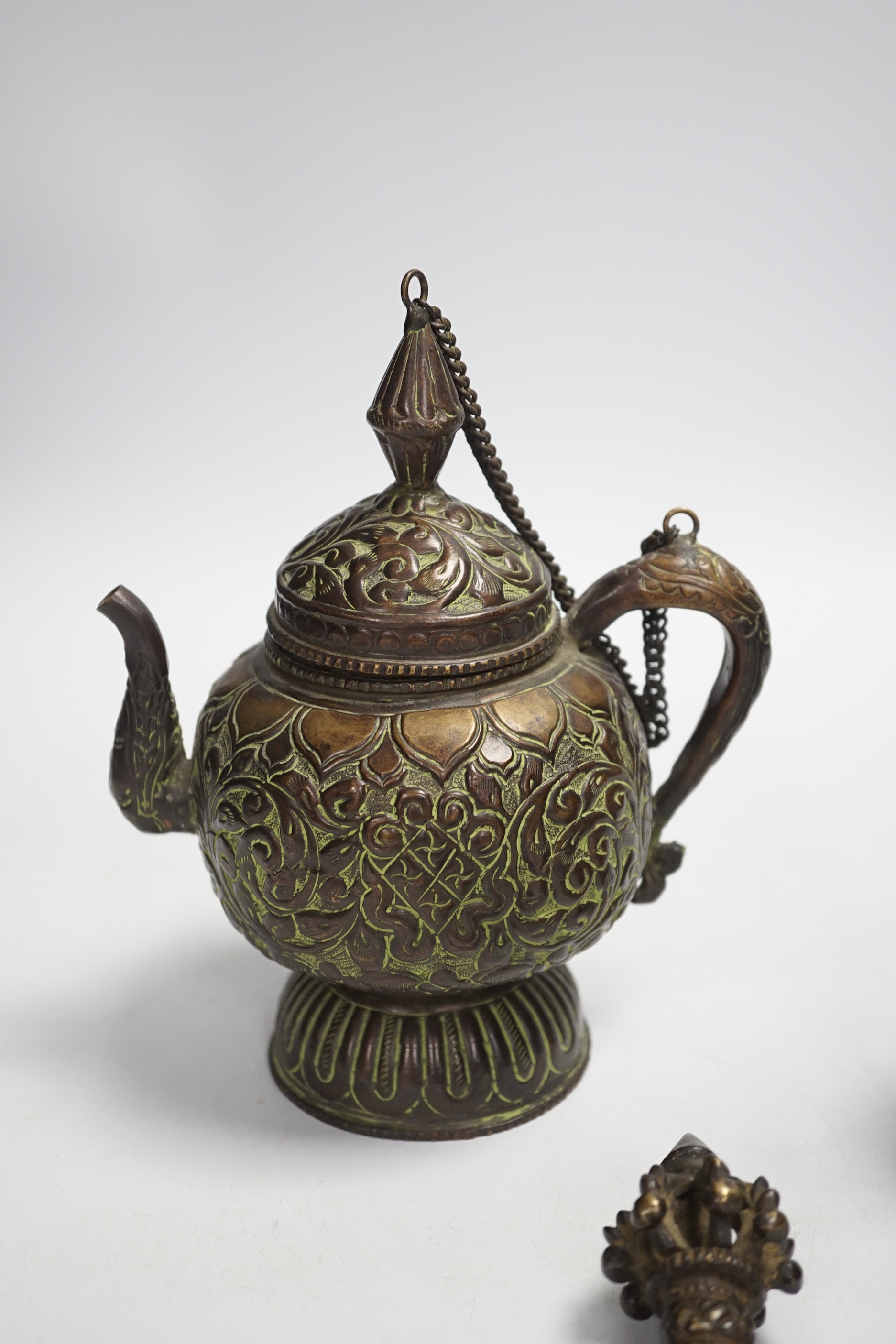 A Tibetan repousse teapot, a ghanta bell and a kartika chopper, tallest 19cm